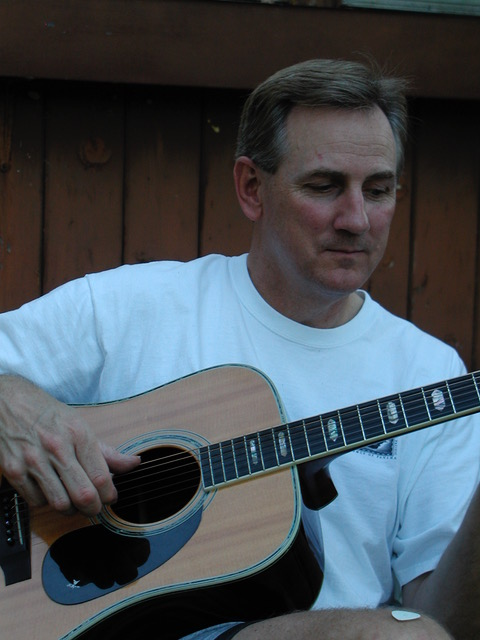 Kyle Freeman playing an acoustic guitar in 1989